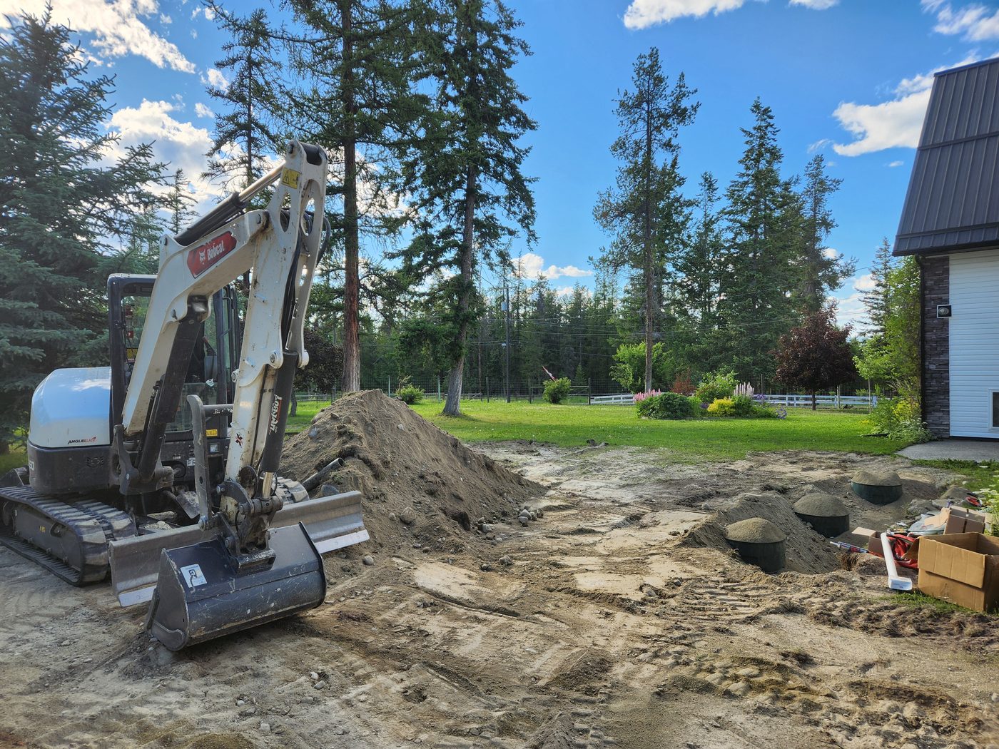 Septic tanks set and backfilled beside a home